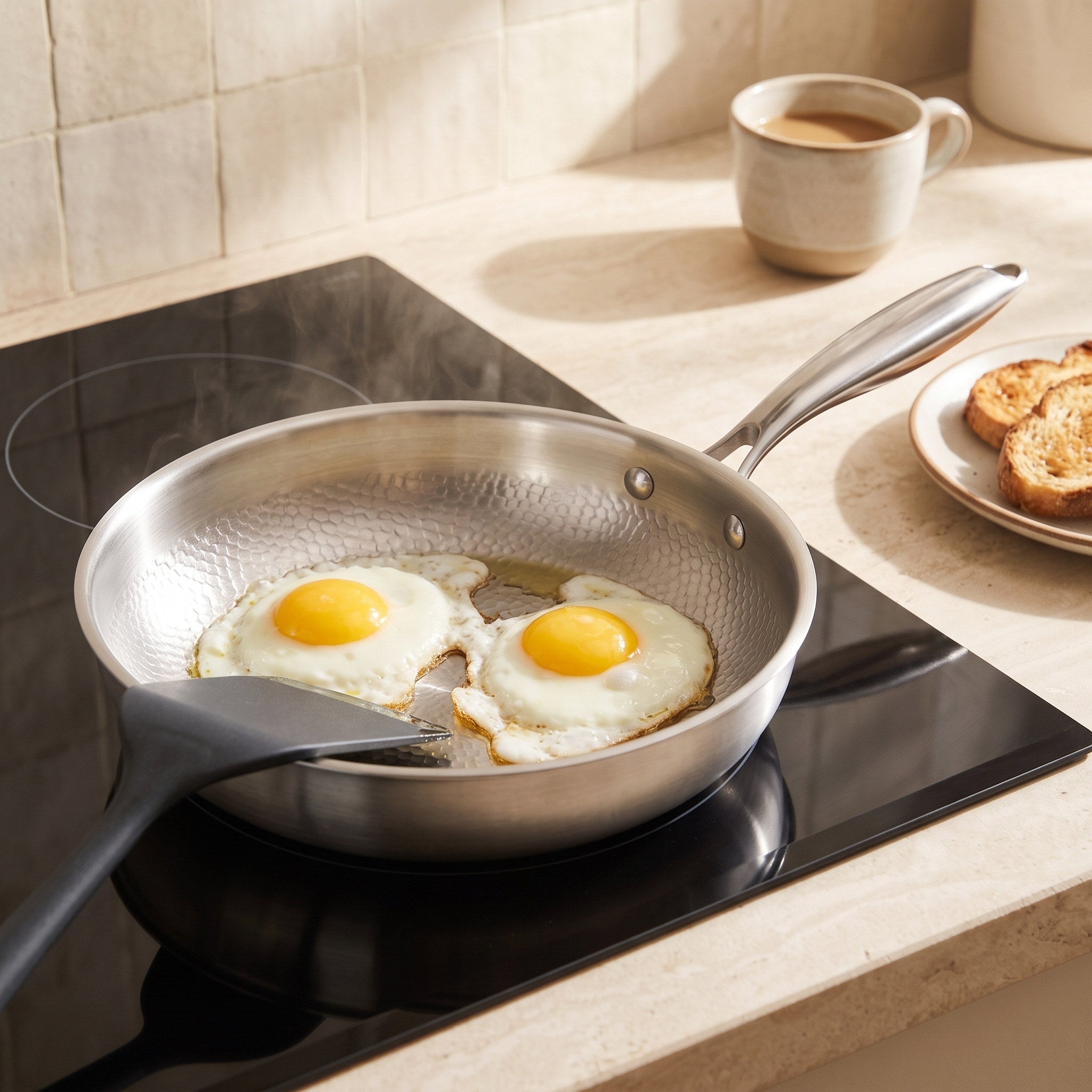 Eggs cooking in a hammered frying pan in morning kitchen light
