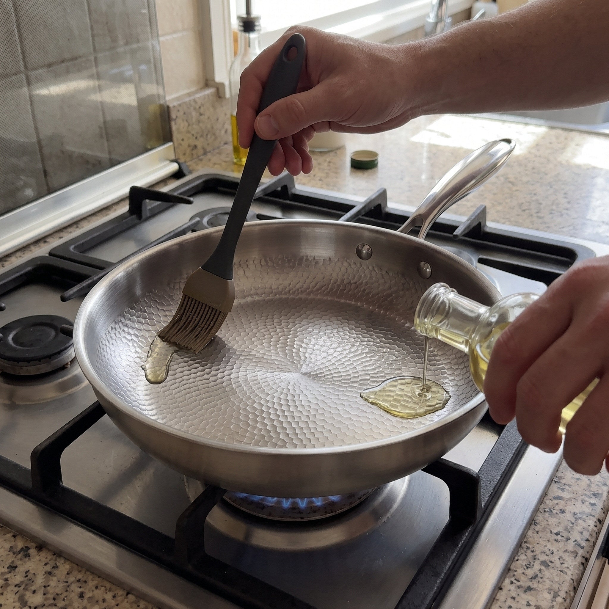 Oil being spread over the warmed hammered pan before cooking