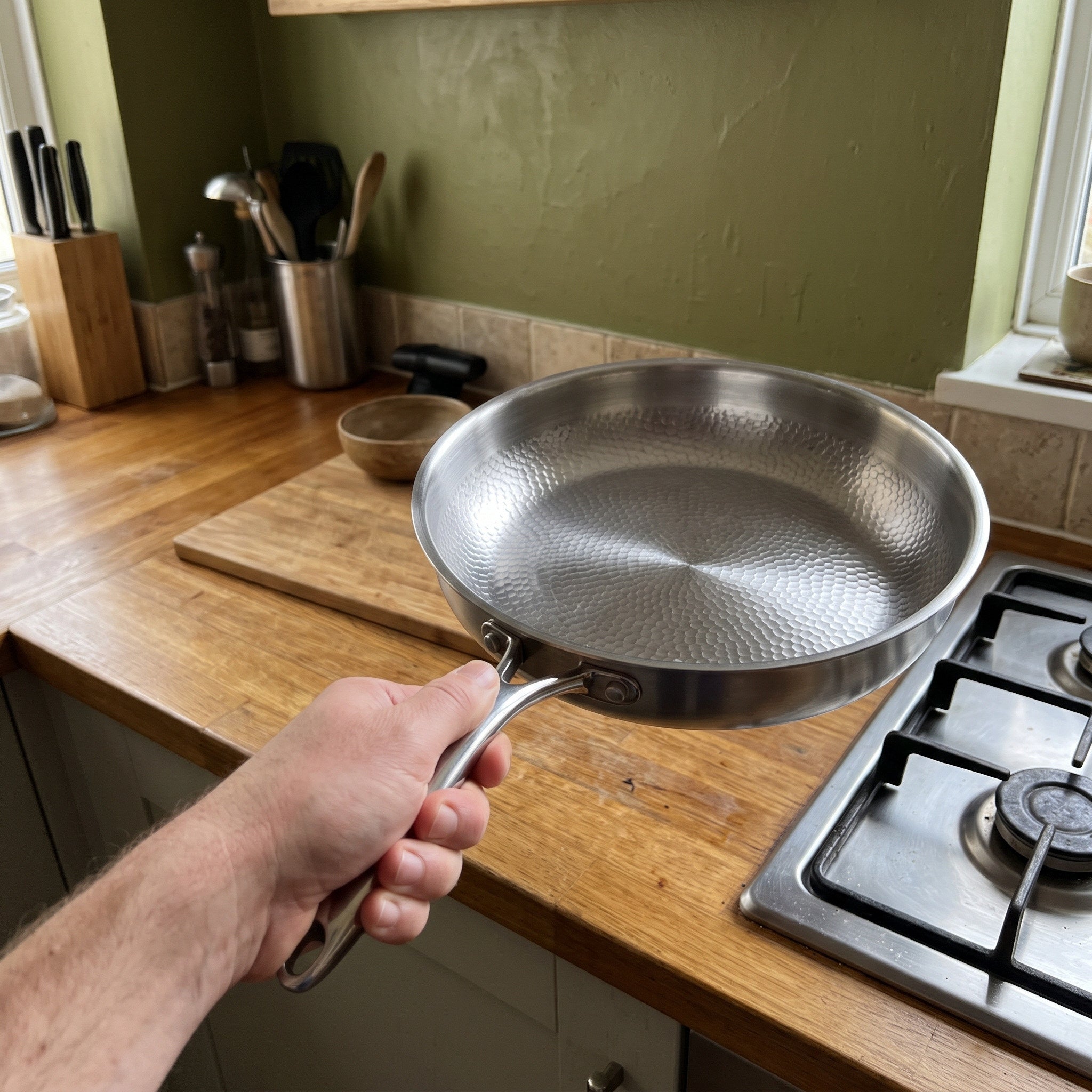 Hand moving a cold pan to the hob