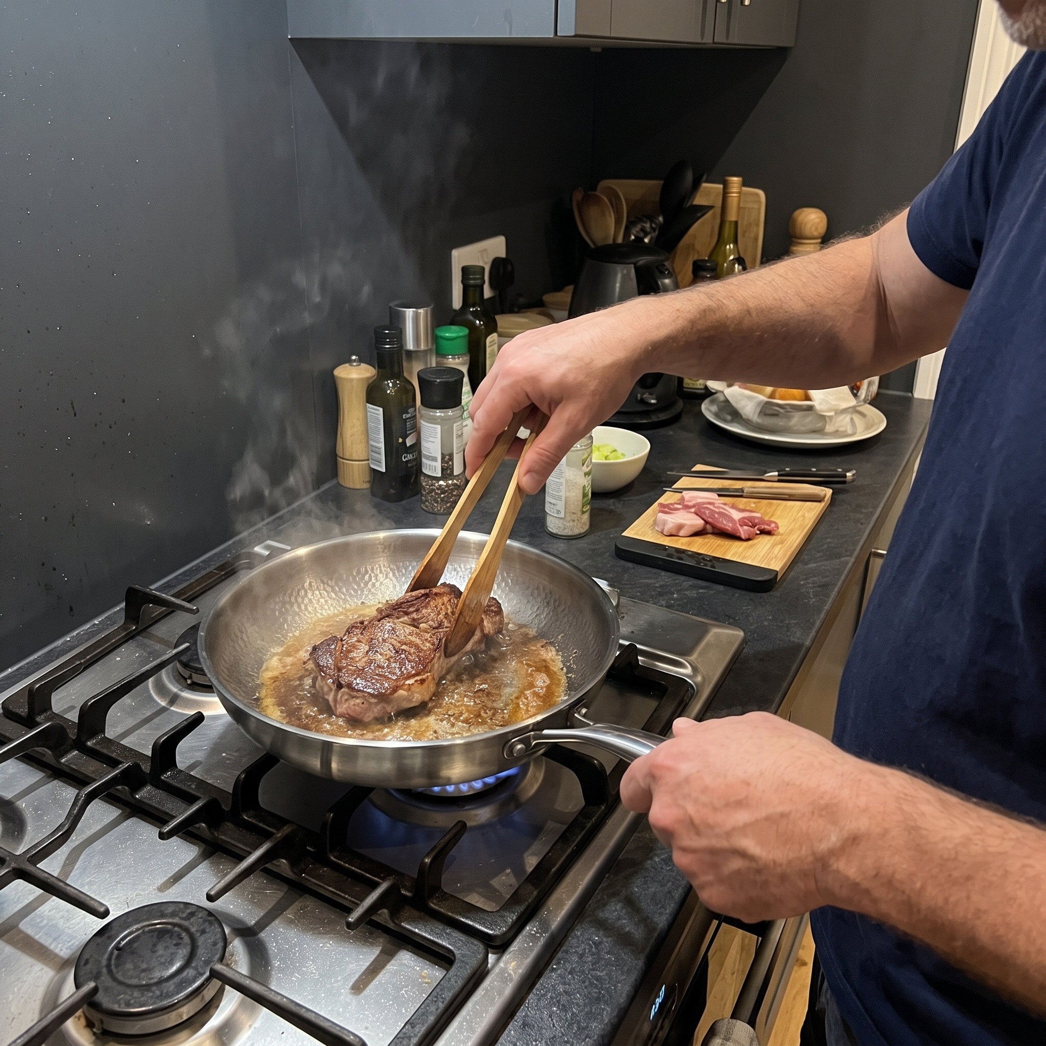 Owner point of view turning steak with wooden tongs